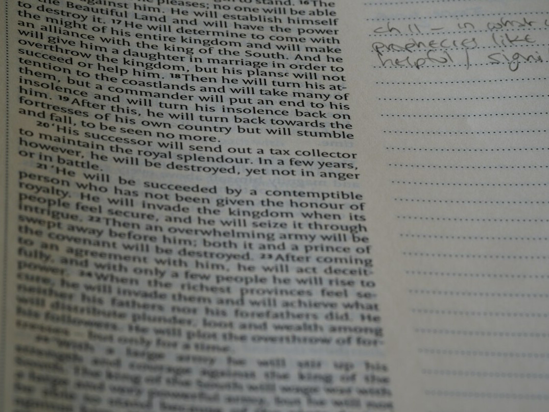 Handwritten notes on a desk with a pen