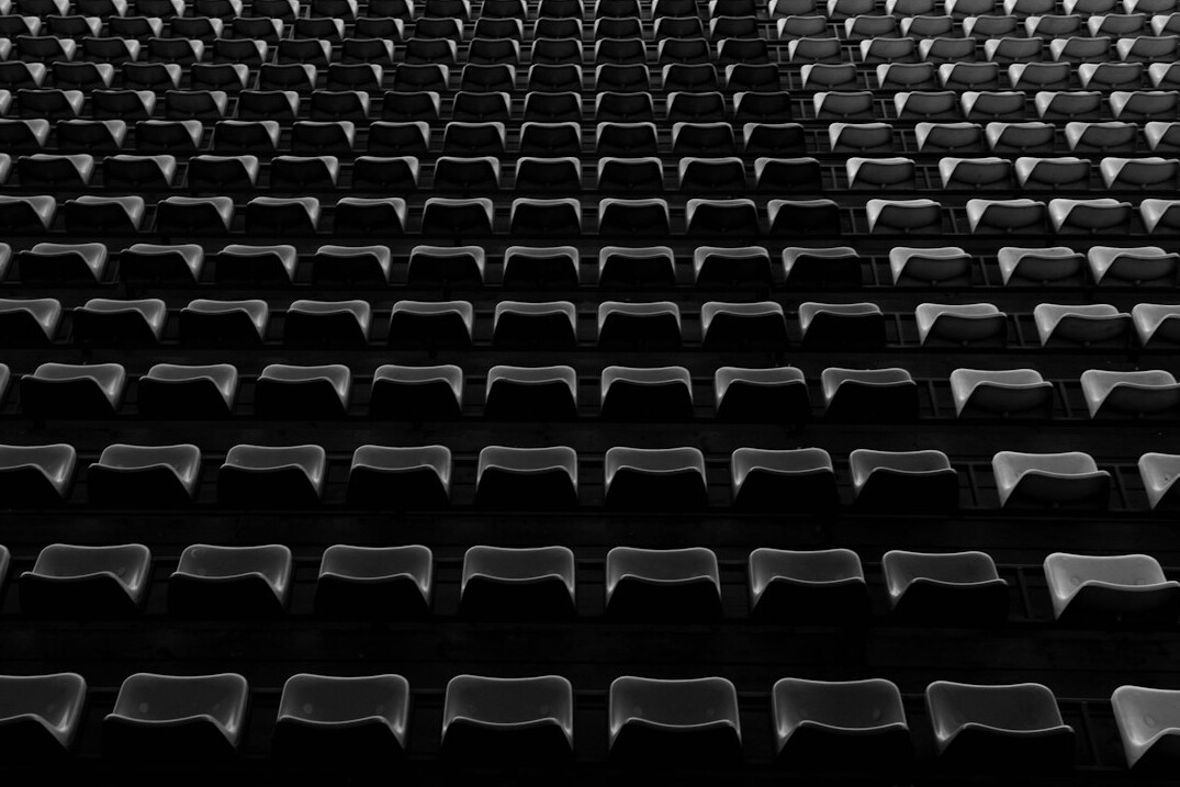 Rows of empty theater seats in dim light